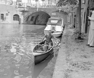 885016 Afbeelding van een Canadese roeier op de Oudegracht bij de Stadhuisbrug te Utrecht, die aanmeert aan de werf, ...
